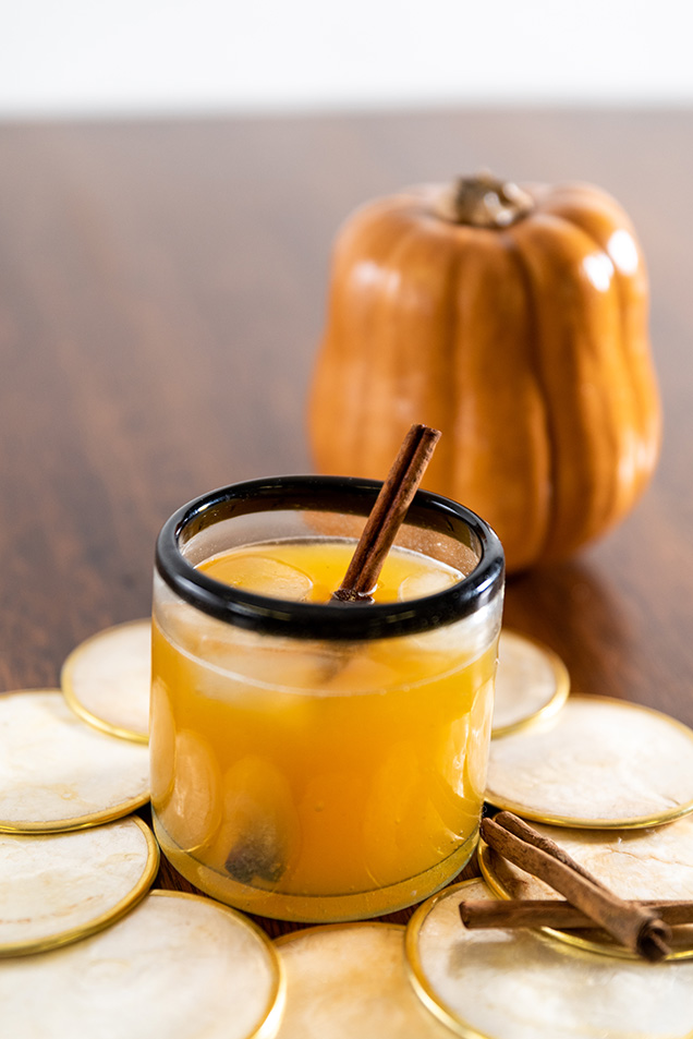 orange drink with straw in front of small pumpkin